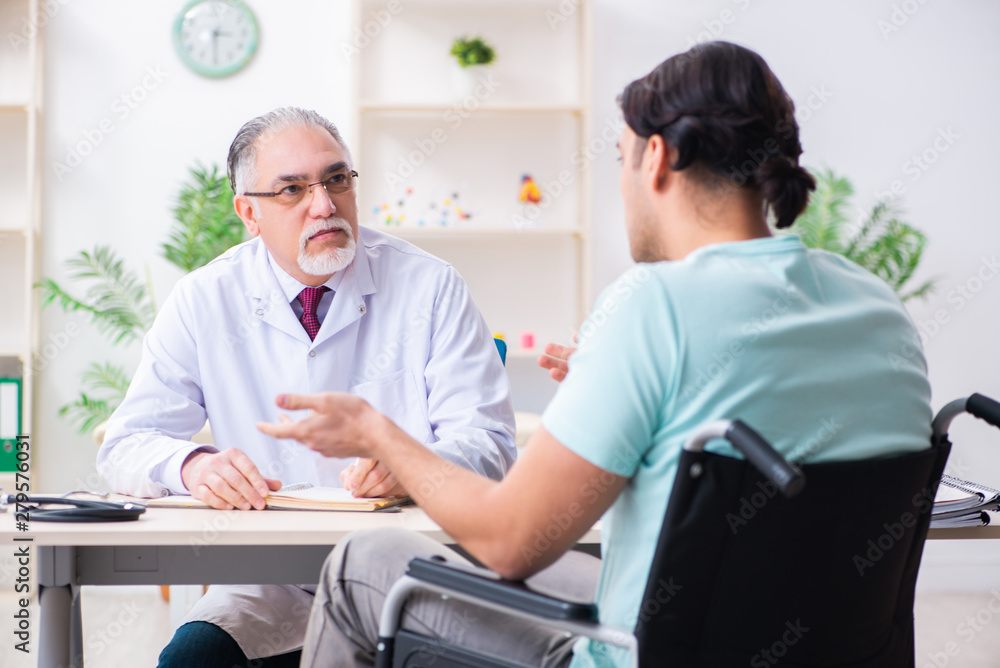 Obraz premium Male patient in wheel-chair visiting old doctor