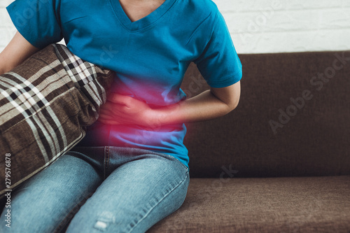 woman having cramps on sofa