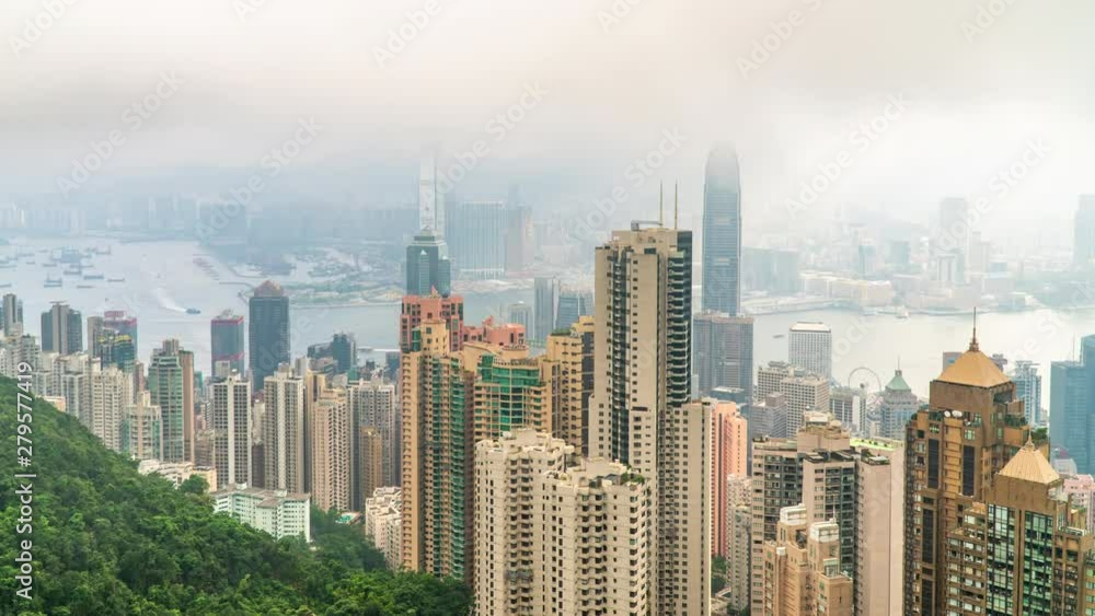 4K Timelapse wide shot high angle view of moving cloud over skyscraper cityscape construction industry building tower and water transportation logistic form Victoria Peak harbour, Hong Kong, China. 4K Timelapse wide shot high angle view of moving cloud over skyscraper cityscape construction industry building tower and water transportation logistic form Victoria Peak harbour, Hong Kong, China.