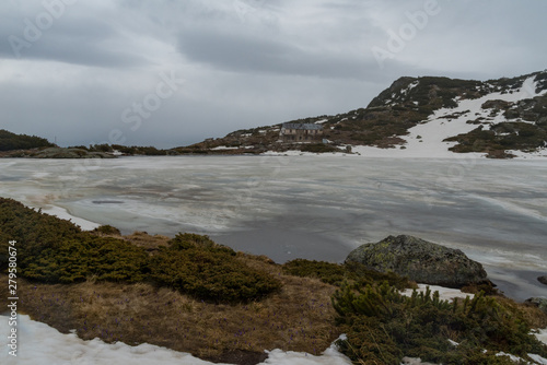 Winter mountain landscape in Bulgaria,  Ribnoto (Fish) lake with refuge Seven Lakes at background. Rila mountain.