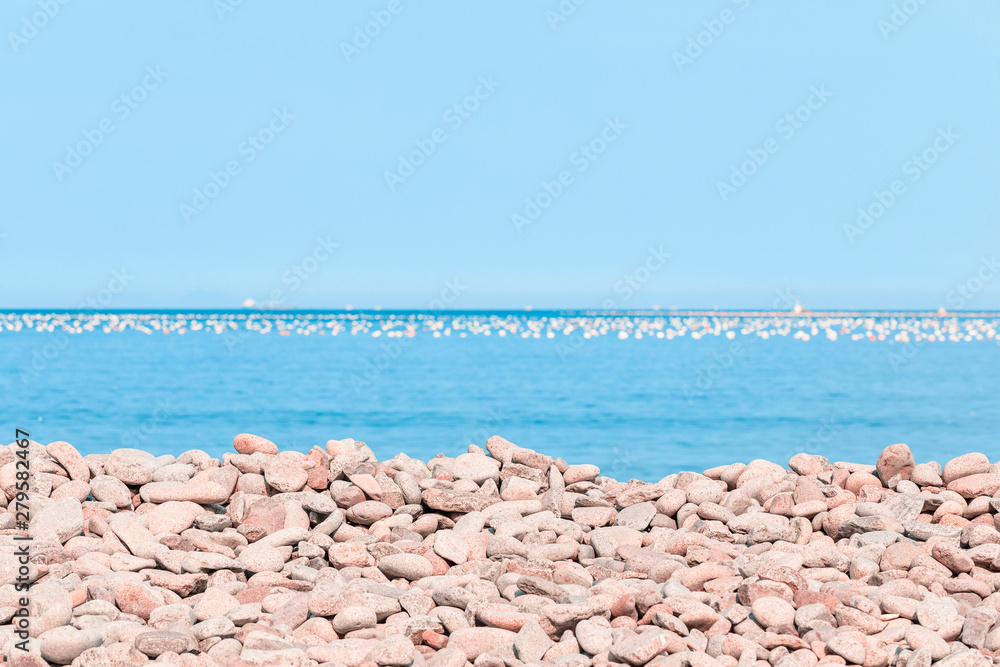 Fototapeta premium Pebble beach and blue sky on background