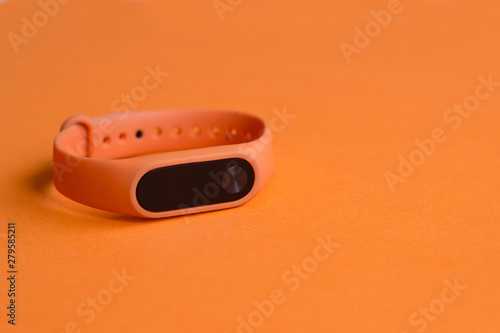 Wallpaper Mural Orange fitness tracker on an orange background close up. Torontodigital.ca