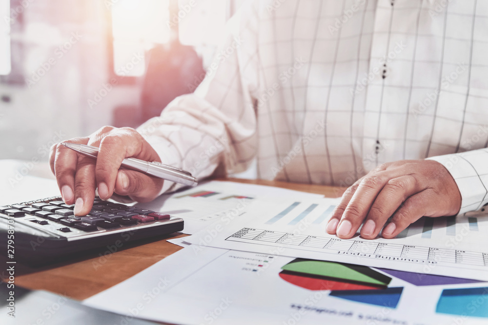 businesswoman working on desk in office and using calculator and laptop businesswoman working on desk in office and using calculator and laptop