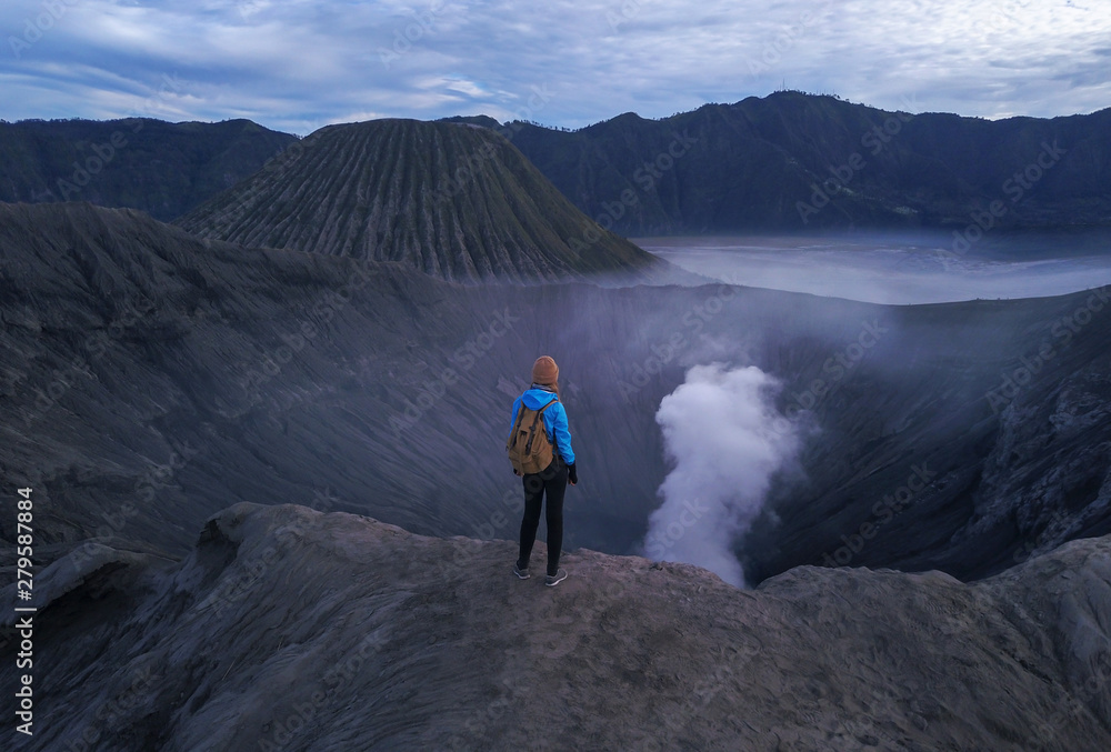 Woman standing on edge of crater  Bromo volcano, East Java, Indonesia