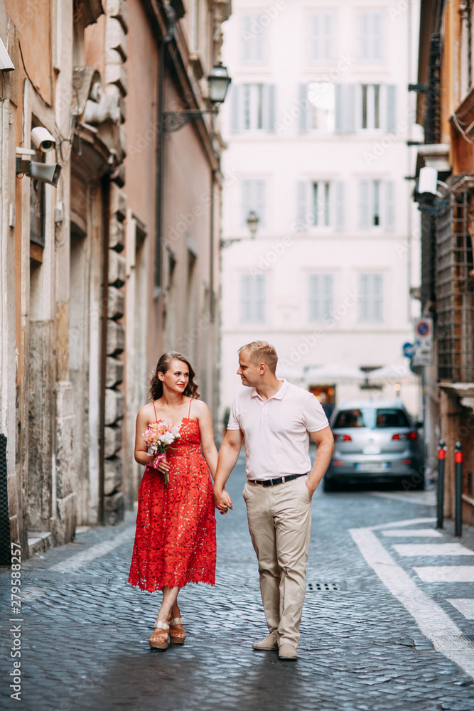 Stylish loving couple walking and laughing. Wedding shooting on the streets of Rome, Italy.