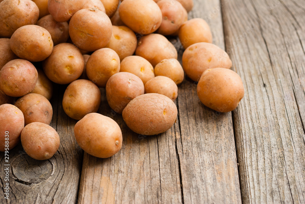 petite potatoes on rustic wood table background petite potatoes on rustic wood table background