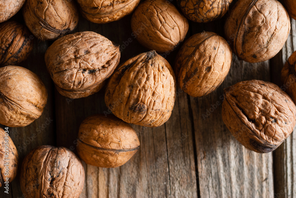 walnuts on old wooden table directly above walnuts on old wooden table directly above
