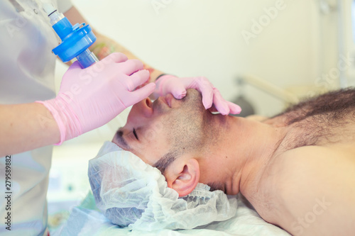 Anesthesiologist performing tracheal intubation in operation room. Preparation for surgery.