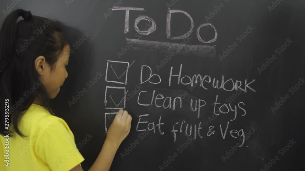 Female elementary school student making to do list on the chalkboard. Shot in 4k resolution Female elementary school student making to do list on the chalkboard. Shot in 4k resolution