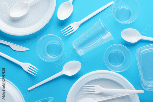 Various white plastic disposable tableware on blue background. photo