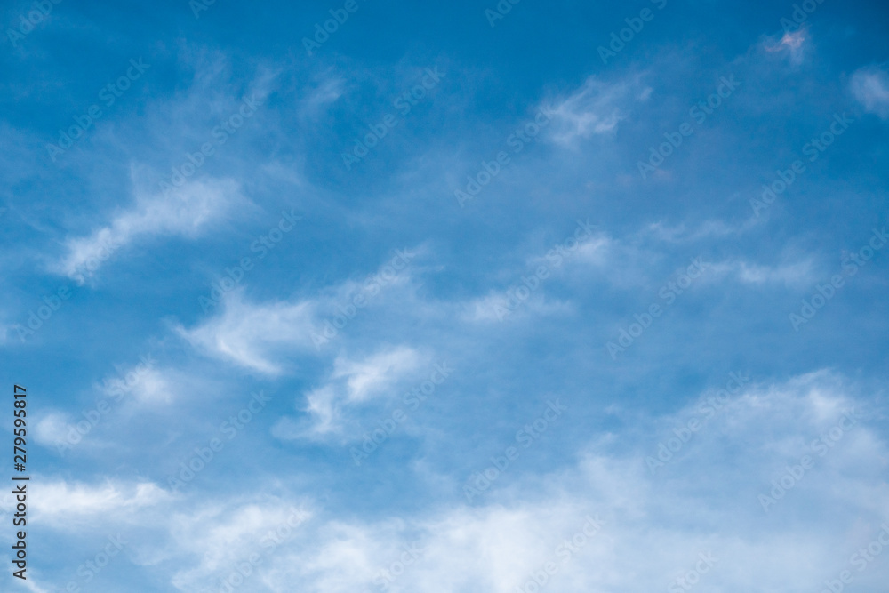 The blue sky with moving white clouds. The sky is a beautiful color shade suitable for use as a background image. The blue sky with moving white clouds. The sky is a beautiful color shade suitable for use as a background image.