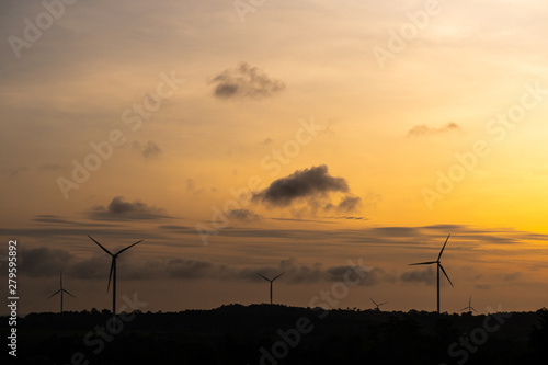 silhouette of wind turbine located on a ridge with wind blowing all the time. Making it able to effectively produce renewable electricity, which is another clean energy.