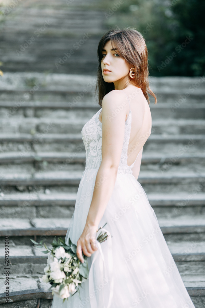 Bride with long dress in nature with sunset. A stylish wedding in the European style of fine art. Bride with long dress in nature with sunset. A stylish wedding in the European style of fine art.