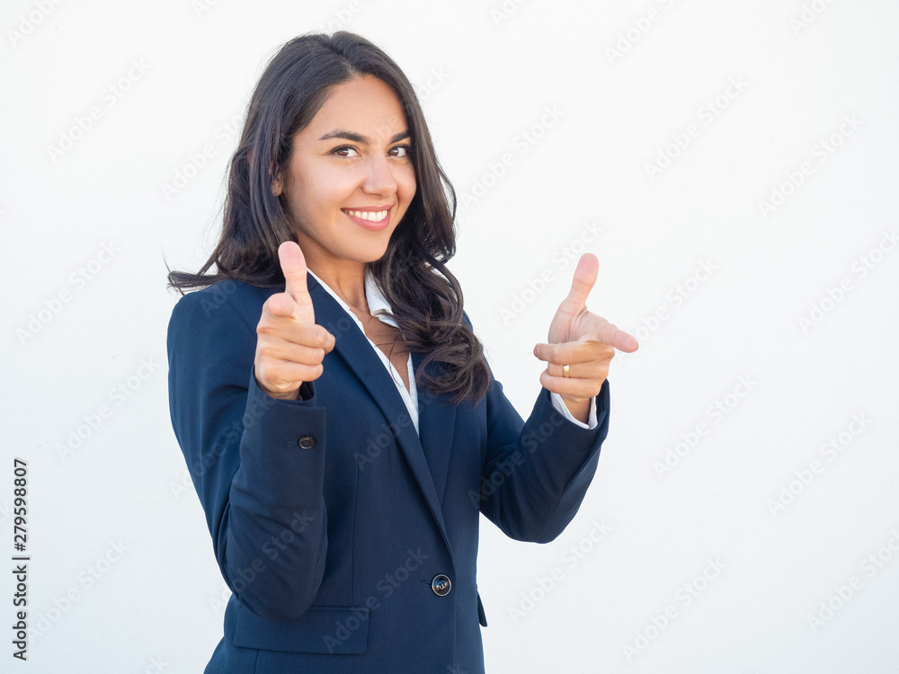 Friendly smiling female manager choosing you. Happy beautiful black haired young woman in formal suit pointing index fingers at camera. Choice or selection concept Friendly smiling female manager choosing you. Happy beautiful black haired young woman in formal suit pointing index fingers at camera. Choice or selection concept