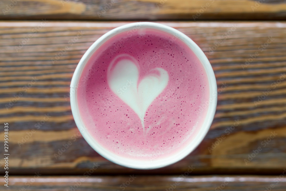 Pink coffee cup with heart shape latte art on wooden background, toned.  Love, Invitation, Valentine's Day concept. Top view, flat lay, copy space  Stock Photo