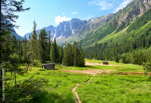 Log huts of mineral baths in meadow. Mineral springs Choigan