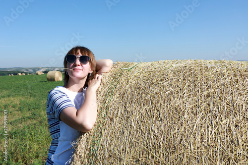 Tourist posing with bales of straw