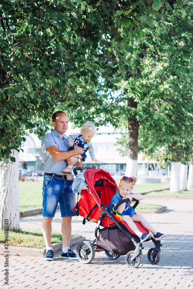 father performs parental duties, stroller, summer, caucasian family father performs parental duties, stroller, summer, caucasian family