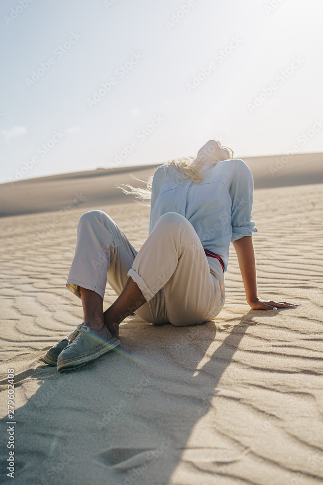 Woman Sitting On Sand In Desert Woman Sitting On Sand In Desert