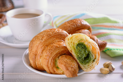 Croissants filled with pistachio cream praline as delicious breakfast with coffee