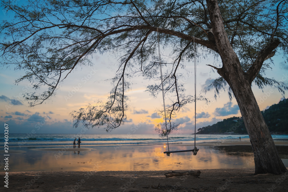 Big tree and wooden swing seat on sunset background. Big tree and wooden swing seat on sunset background.