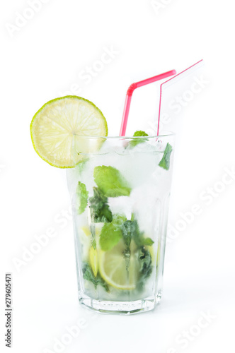 Mojito cocktail in a transparent glass with ice. Recipe for exotic drinks with mint, lime and white rum. Glass with a cocktail on a white background in the rays of the sun.