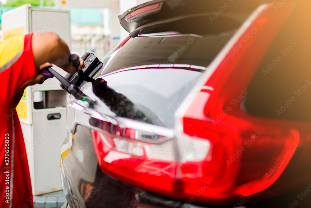Selcective focus to staff using squeegee to clean the Rear window car. Car service in gas station. Selcective focus to staff using squeegee to clean the Rear window car. Car service in gas station.