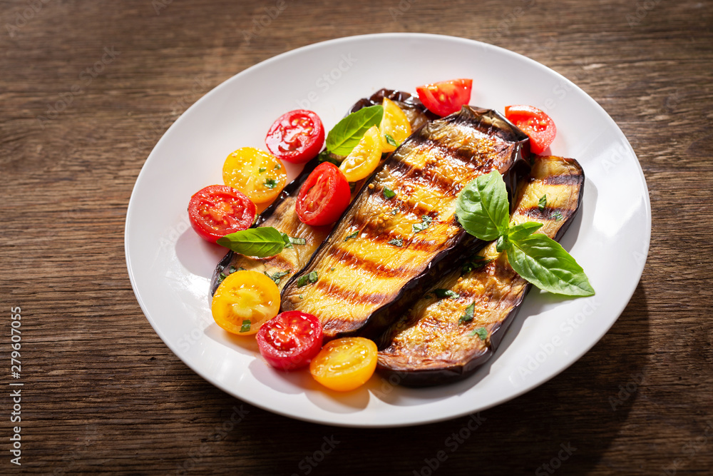plate of grilled eggplants with tomatoes and green basil plate of grilled eggplants with tomatoes and green basil