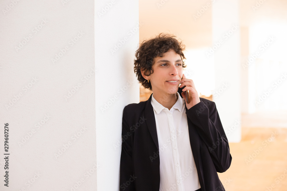 Smiling woman talking by cell phone. Happy professional businesswoman talking by smartphone and looking away indoors. Connection concept Smiling woman talking by cell phone. Happy professional businesswoman talking by smartphone and looking away indoors. Connection concept