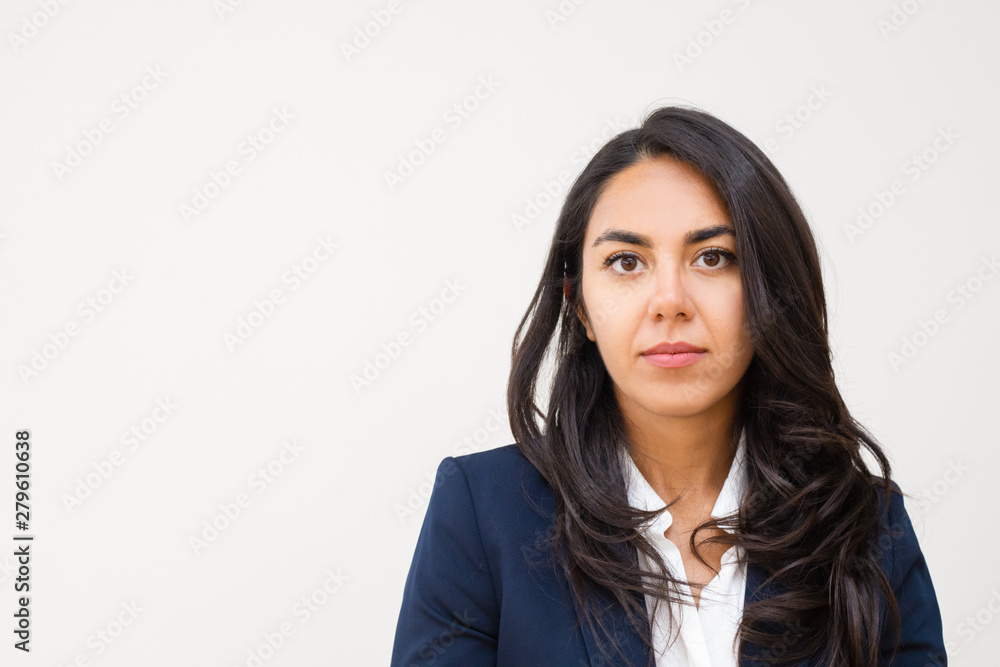 Serious young businesswoman. Portrait of beautiful young brunette businesswoman looking at camera isolated on grey background. Emotion concept Serious young businesswoman. Portrait of beautiful young brunette businesswoman looking at camera isolated on grey background. Emotion concept