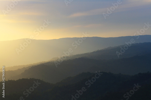 Beautiful landscape layers of mountain and Misty on hill valley in golden twilight of sunset at Thailand