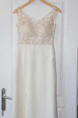 Beautiful clothing dress for bride in salon hang in wood door