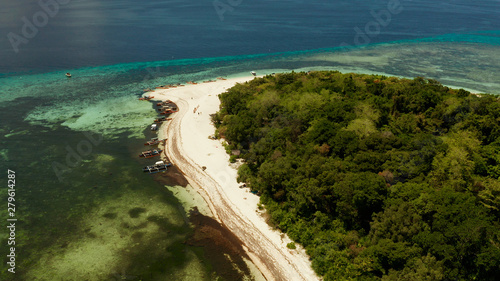 Tropical island and sandy beach surrounded by atoll coral reef and blue sea, aerial view. Small island with sandy beach. Summer and travel vacation concept, Mantigue Philippines Mindanao