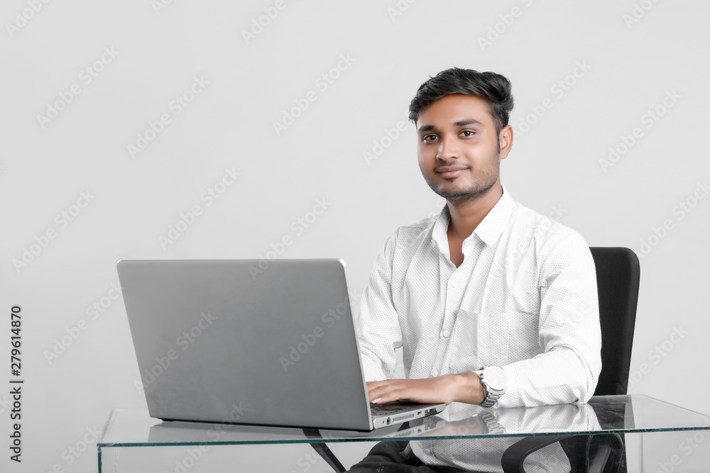 young indian man working at office young indian man working at office