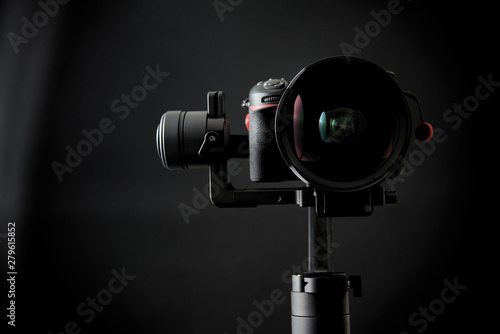 Close-up of gimbal stabilizer, and dsl camera with low-key lighting and a black background photo