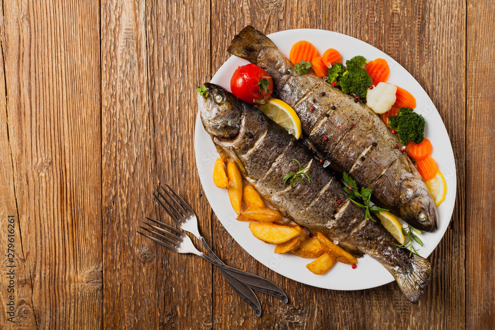 Grilled whole trout. Served with baked potatoes. Grilled whole trout. Served with baked potatoes.