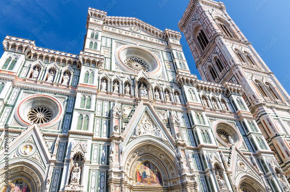 Florence Duomo beautiful marble facade, Cattedrale di Santa Maria del Fiore, Basilica of Saint Mary of the Flower Cathedral on Piazza del Duomo square in sunny day with clear blue sky, Tuscany, Italy