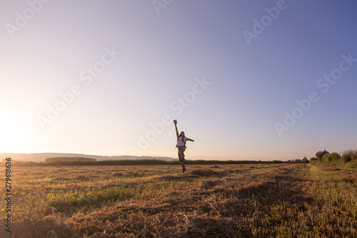 backpacker traveler walking at sunrise and throwing hat in the wind