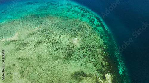 Tropical island and sandy beach surrounded by atoll and coral reef with turquoise water, aerial drone. Tropical island and coral reef. Summer and travel vacation concept, Camiguin, Philippines