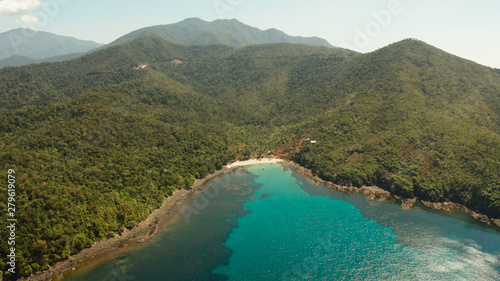 Aerial view beautiful tropical beach in the cove with blue lagoon and turquoise water surrounded by rainforest. Palawan, Philippines. tropical landscape. Seascape island and clear blue water. Summer