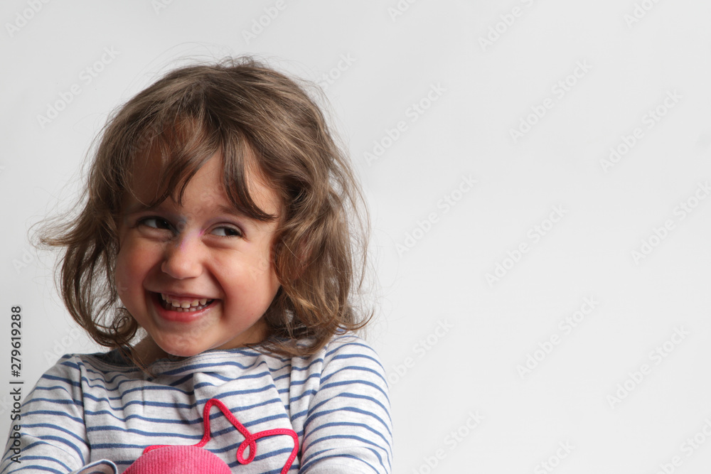 Portrait on white background of a 3-4 year old girl playing and laughing Portrait on white background of a 3-4 year old girl playing and laughing