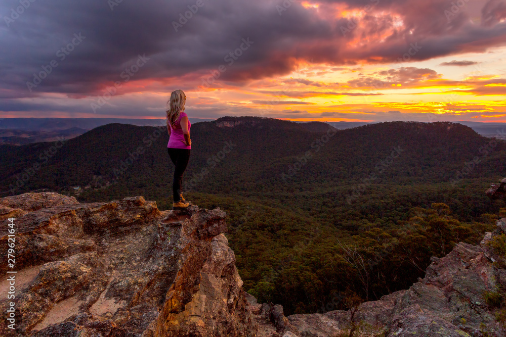 Fototapeta premium Woman watching storm clouds over Blue Mountains at sunset