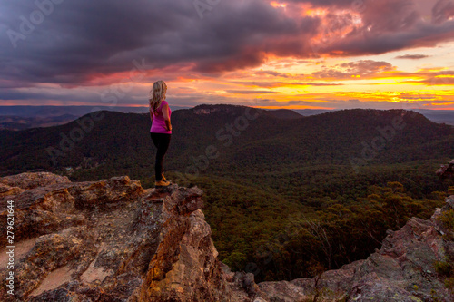 Woman watching storm clouds over Blue Mountains at sunset