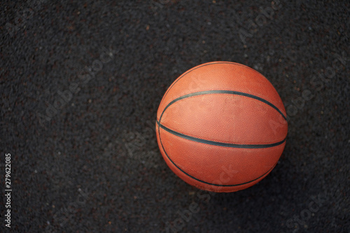 Basketball ball on the black background of outdoor street court © Kiryl Lis