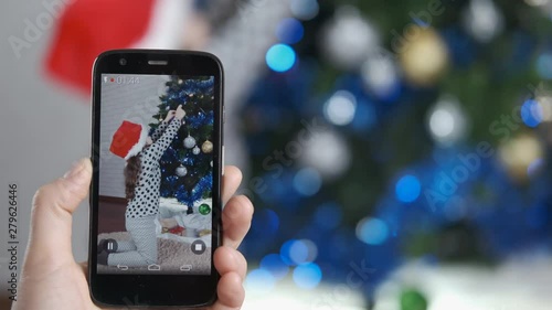 Wallpaper Mural Christmas video. Mother reads to her smartphone, like a daughter decorates a Christmas tree. Torontodigital.ca