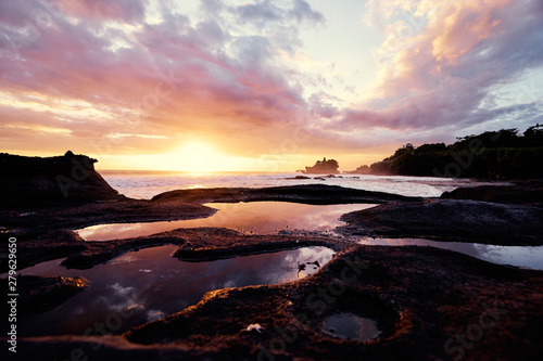 Beautiful balinese landscape. Ancient hinduism temple Tanah lot on the rock against sunset sky. Bali Island  Indonesia.