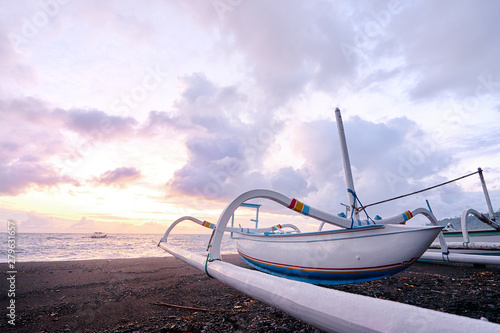 Beautiful sunrise. Ocean, beach and indonesian fishing boats. photo