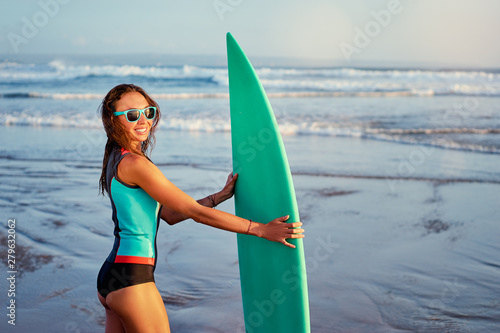 Hobby and vacation. Holiday on the beach. Portrait of surfer. Pretty young woman holding surfboard.