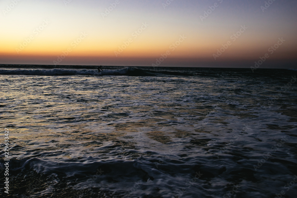 Person surfing at sunset at Sidi Kaouki