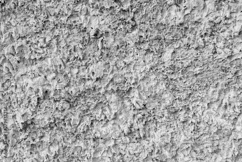 Gray texture of uneven plaster on the wall of the house.